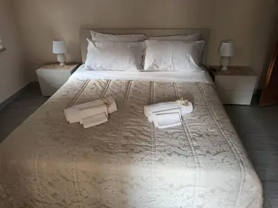 a large white bed with two towels on it at Casa TerraMare in Palermo