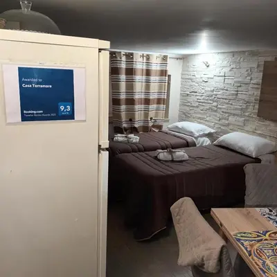 a room with two beds and a tv on the wall at Casa TerraMare in Palermo