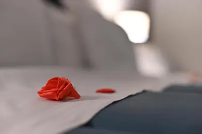 a red rose on a piece of paper on a bed at Boscò Suites in Carini