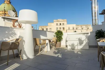 a patio with chairs and a table on a roof at Peonia Boutique Apartments in Palermo
