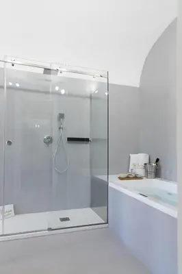 a glass shower in a bathroom with a tub at Peonia Boutique Apartments in Palermo