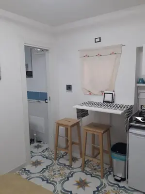 a kitchen with a table and two stools at Oneto Apartment in Palermo