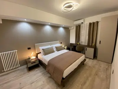 a bedroom with a large bed and a desk with a lamp at Hotel Plaza Ungheria in Palermo