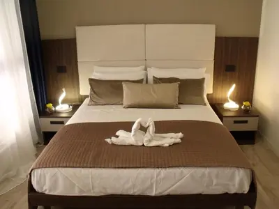 a bedroom with a large bed with two candles at Hotel Plaza Ungheria in Palermo