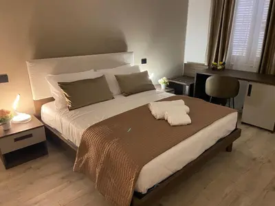 a bedroom with a large bed and a desk at Hotel Plaza Ungheria in Palermo