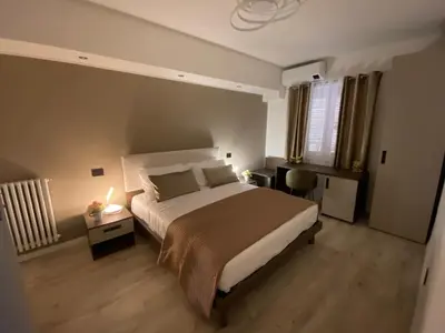 a bedroom with a bed and a desk and a bed sidx sidx sidx at Hotel Plaza Ungheria in Palermo