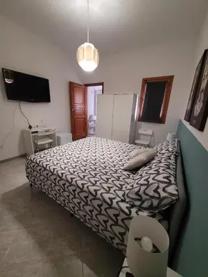 a bedroom with a large bed and a television at Casa Makira in Terrasini