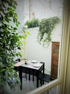 a table and chairs in a room with plants at Nostrale bnb in Palermo
