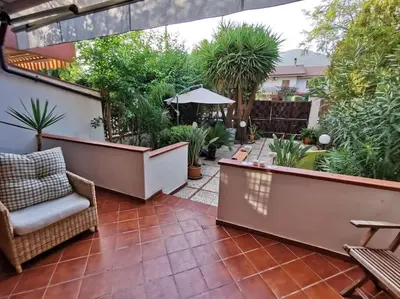 an outdoor patio with a table and chairs and plants at Villa Iris - Mondello in Palermo
