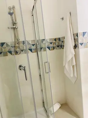 a shower with a glass door in a bathroom at Chalaroste home in Terrasini