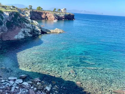 a large body of water with a rocky shore at Chalaroste home in Terrasini