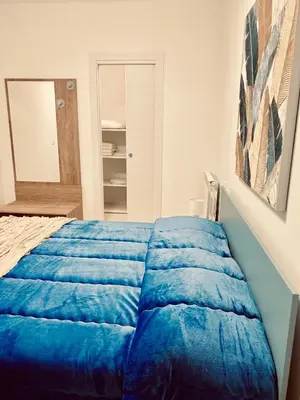 a blue bed in a room with a mirror at Chalaroste home in Terrasini