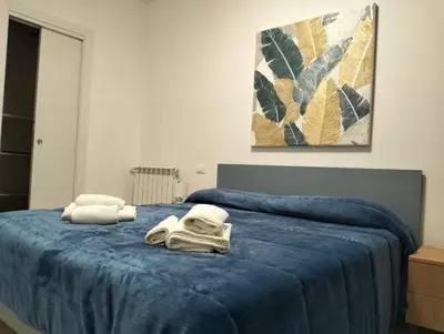a bedroom with a blue bed with towels on it at Chalaroste home in Terrasini