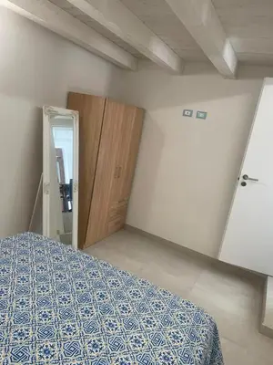 a bedroom with a bed and a wooden door at appartamento francy solare in Castellammare del Golfo