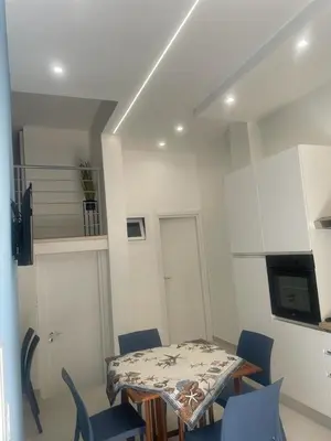 a dining room with a table and blue chairs at appartamento francy solare in Castellammare del Golfo