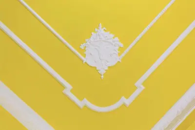 a white decoration on a yellow wall at Bohème B&B in Palermo