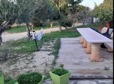 a picnic table and a bench in a park at Camera Tina in Castellammare del Golfo