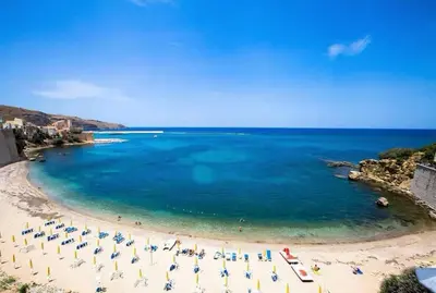 a beach with umbrellas and chairs and the ocean at Camera Tina in Castellammare del Golfo