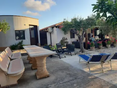 a group of chairs and a wooden table and chairs at Camera Tina in Castellammare del Golfo