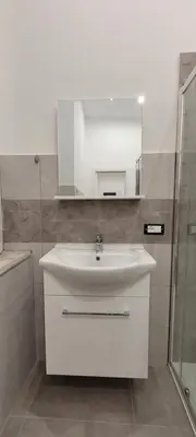 a bathroom with a white sink and a mirror at HouseStation Suite in Palermo
