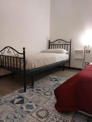 a bedroom with two beds and a rug at HouseStation Suite in Palermo