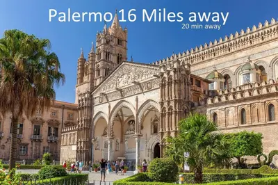 a large building with a clock tower and a cathedral at Villa San Lorenzo Sicily in Altavilla Milicia