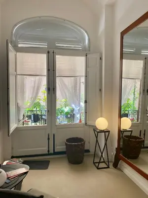 a living room with two large windows and a mirror at Casa 3D'Oro Palermo in Palermo