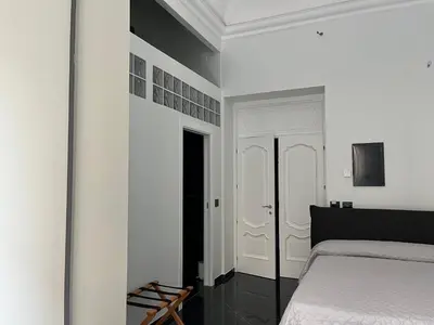 a bedroom with a bed and a white wall at La Dimora di Donna Claudia in Palermo