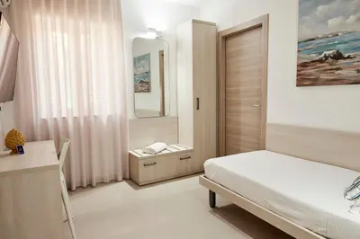 a bedroom with a bed and a mirror at Kalsa Sicilian Rooms in Partinico