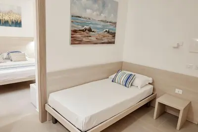 a small bed in a room with a painting on the wall at Kalsa Sicilian Rooms in Partinico