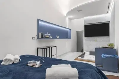 a bedroom with a bed and a tub and a tv at I Cappuccini Suite in Palermo