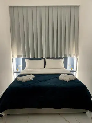 a bed with two towels on it in front of a window at I Cappuccini Suite in Palermo