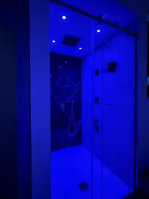 a dark room with a shower with blue lights at I Cappuccini Suite in Palermo