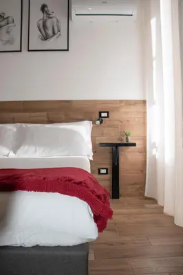 a bedroom with a bed with a red blanket on it at Maison L'amuri in Palermo