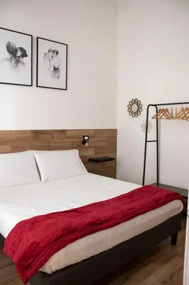 a bedroom with a bed with a red blanket on it at Maison L'amuri in Palermo