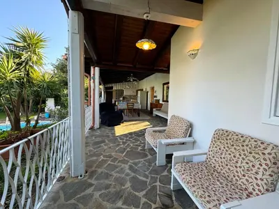 a porch with two chairs and a table at Villa Talìa in Carini