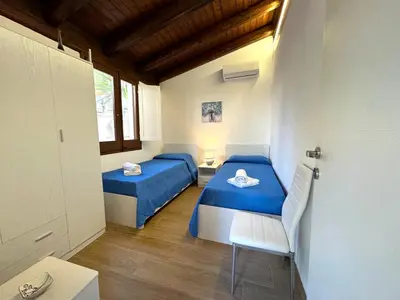 a room with two beds and a chair in it at Villa Talìa in Carini