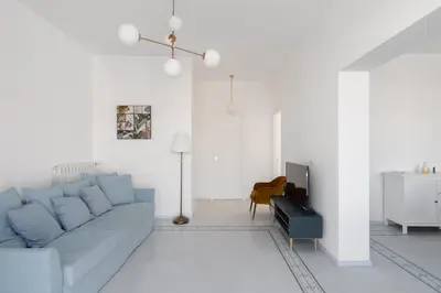 a living room with a blue couch and a tv at Solemar Sicilia - Casa Margherita in Santa Flavia