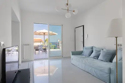 a living room with a couch and a table with an umbrella at Solemar Sicilia - Casa Margherita in Santa Flavia