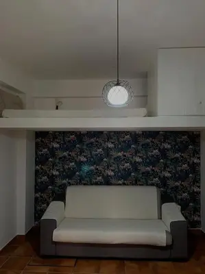 a white couch in a room with a wall at Alloggio incantevole/ bedsitting-room in Altavilla Milicia