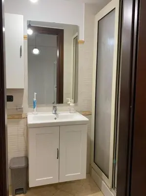 a bathroom with a white sink and a mirror at Alloggio incantevole/ bedsitting-room in Altavilla Milicia