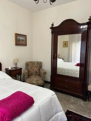 a bedroom with a bed and a mirror and a chair at Holiday & House - Imparato Palermo Centro Politeama in Palermo