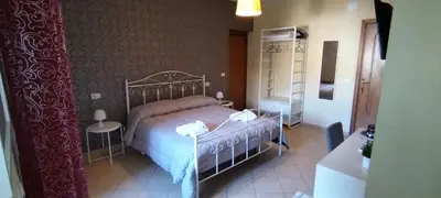 a living room with a bed and a desk with a chair at SUITE PRINCIPE SCORDIA in Palermo