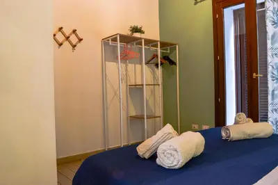 a bedroom with a blue bed with towels on it at Happie Casa La Cattedrale in Palermo