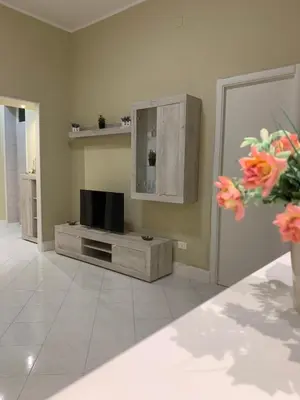a living room with a flat screen tv on a cabinet at Casa Leila in Palermo