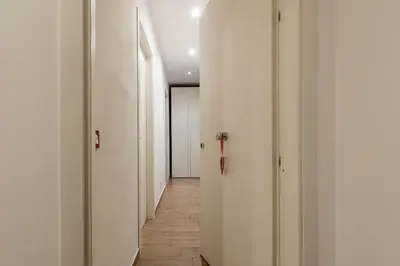 a hallway with white walls and wooden floors at Borsa Apartments by Wonderful Italy in Palermo