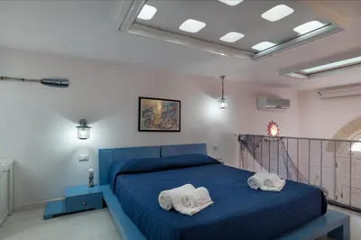 a bedroom with a blue bed with towels on it at Cambusa del Capitano in San Vito lo Capo