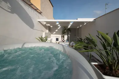 a bath tub filled with water next to a building at Cambusa del Capitano in San Vito lo Capo