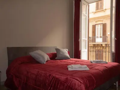 a bedroom with a red bed with a window at Pacini Deluxe Apartment in Palermo