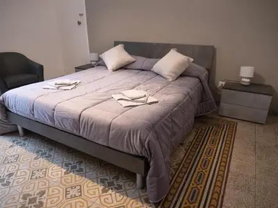 a bedroom with a large bed with two towels on it at Pacini Deluxe Apartment in Palermo